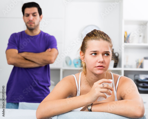 Upset girl at table after discord with man photo