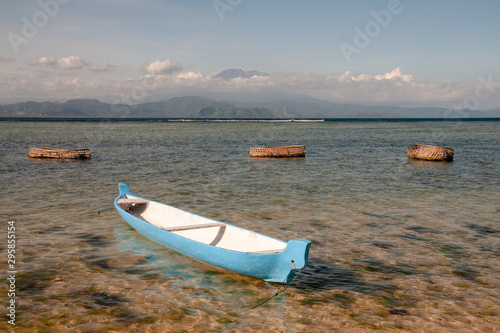 Blue/white fischerman boat and baskets for seaweed at the lagoon at Nusa Lembongan, Bali, IDN photo