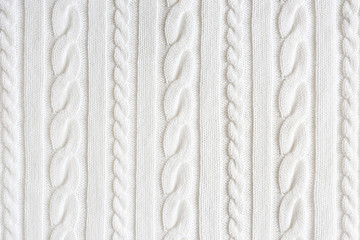 Cropped close up shot of seamless woolen knitting pattern of fall / winter season warm sweater, clearly visible fiber texture of stylish hipster knitwear clothing. Background, copy space, top view.