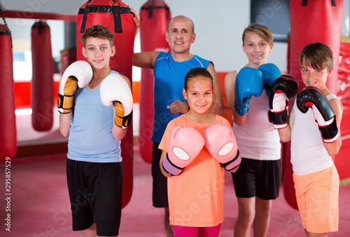 Group of young smiling boxer with coach standing
