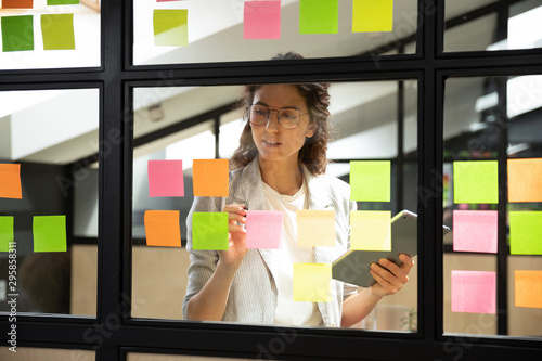 Businesswoman creates priority to-do list on sticky notes photo