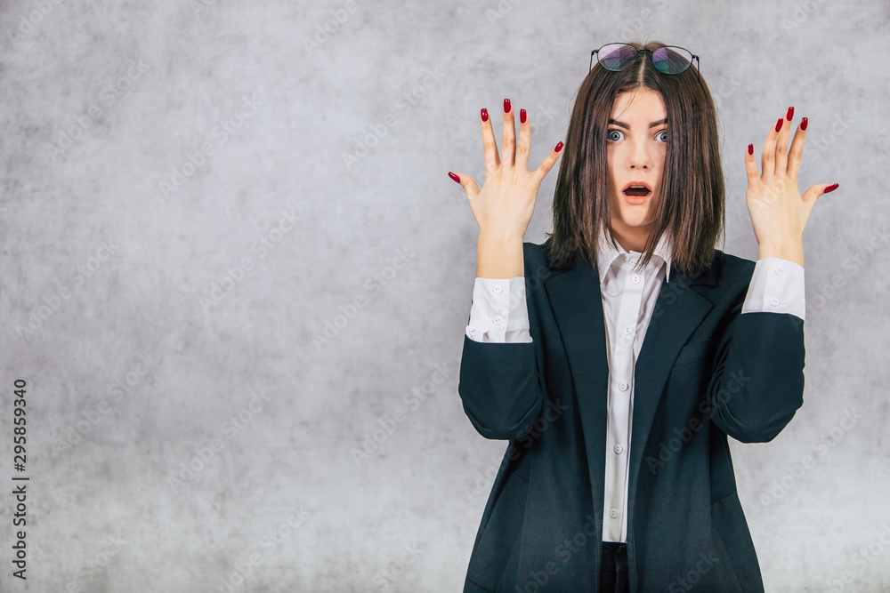 Scared businesslady with glasses on the forehead, raising her hands looking with eyes widely opened. Scared businesslady with glasses on the forehead, raising her hands looking with eyes widely opened.