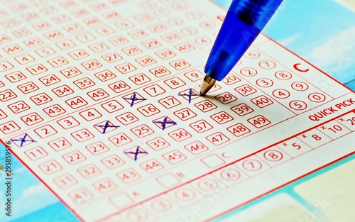 Blue pencil crossing numbers on a lotto paper.