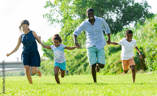 Happy children with parents running in park