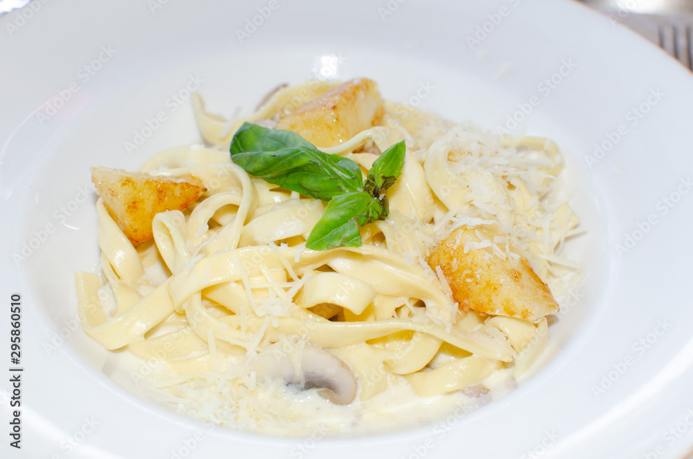 pasta with mushrooms and cream sauce in a white plate