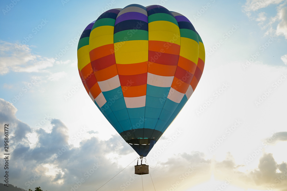 Naklejka premium Ballon na gorące powietrze Coroful latające na niebie z chmurami i górskim tle
