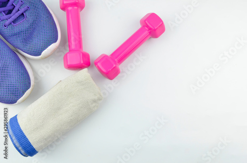 Fitness concept background with sneakers, dumbbells and towel. Top view with space for your text.