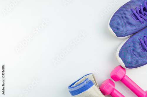 Fitness concept background with sneakers, dumbbells and towel. Top view with space for your text.