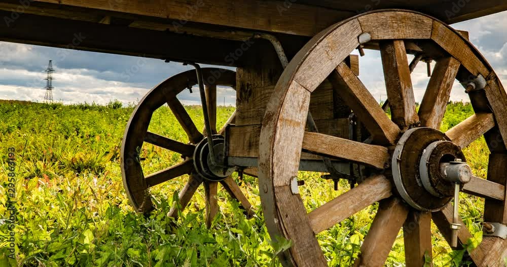 Antique wooden cart standing alone in a field, beautiful autumn landscape, hyperlapse, time lapse, heavy autumn sky