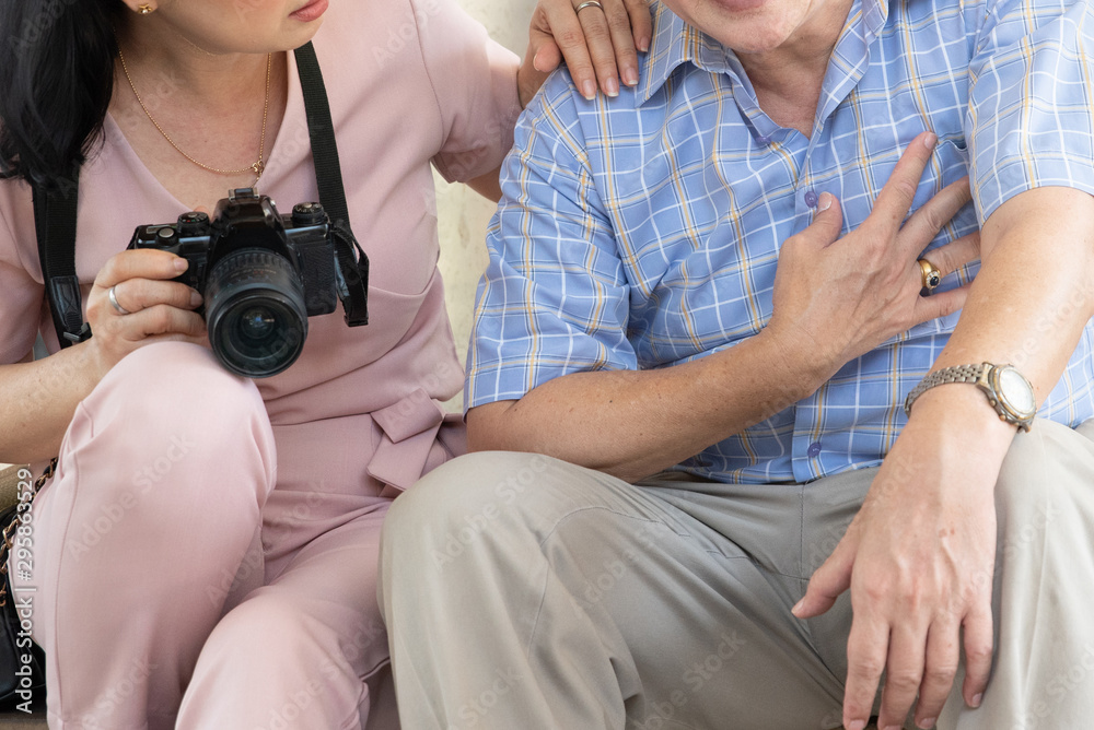 Midsection Of Woman Sitting By Man With Chest Pain Midsection Of Woman Sitting By Man With Chest Pain