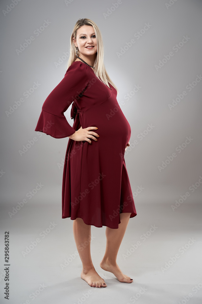 Fototapeta premium Pregnant young woman in red dress