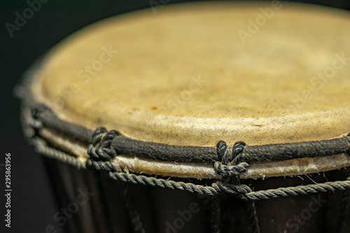 Djembé in the foreground with tension and tuning strings photo
