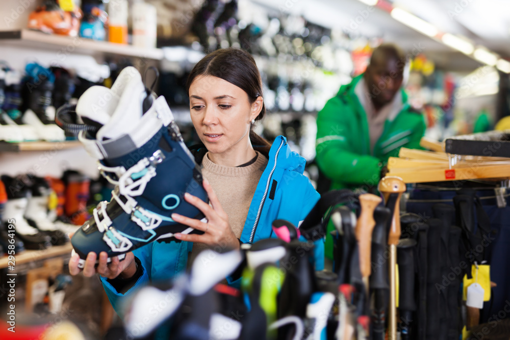 Female looking for new ski boots in shop