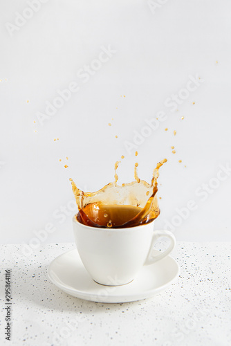 Cup of coffee with splash on white background.