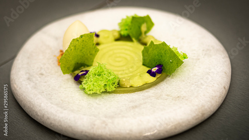 Circular composition with sponge, ice cream and vertical gelling of green fruits and asparagus