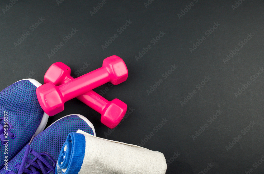 Fitness concept background with sneakers, dumbbells and towel. Top view with space for your text. Fitness concept background with sneakers, dumbbells and towel. Top view with space for your text.