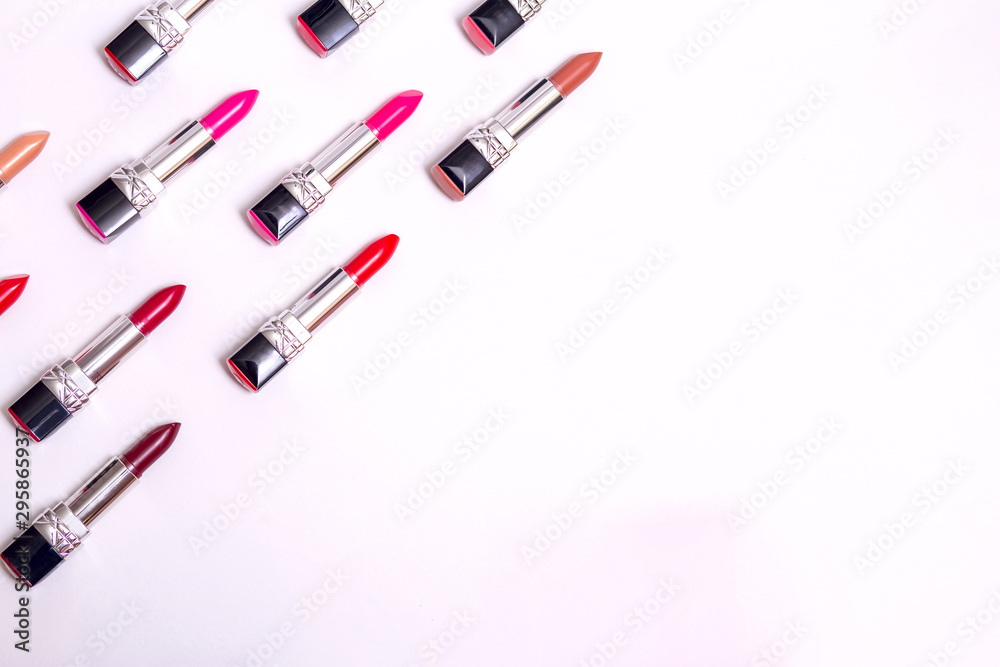 lots of colorful lipsticks lined up in army shape on white background lots of colorful lipsticks lined up in army shape on white background
