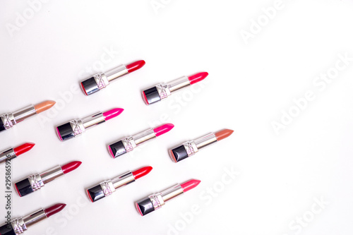 lots of colorful lipsticks lined up in army shape on white background
