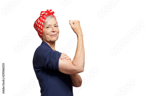 Self-confident senior woman with a clenched fist rolling up her sleeve, isolated on white, copyspace