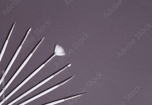 white nail design brushes on gray background