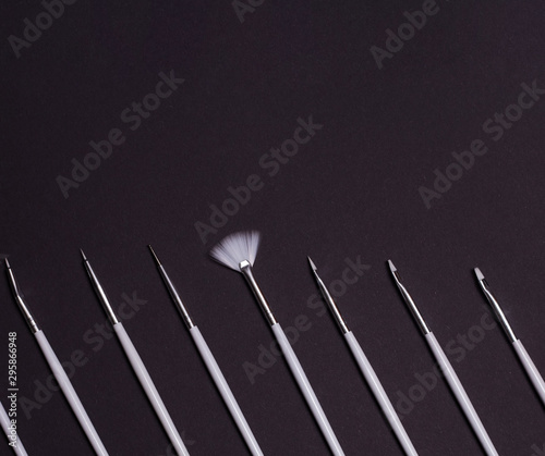 white nail design brushes on black background