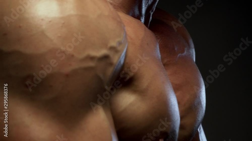 Fitness tanned guy showing muscles, close up
