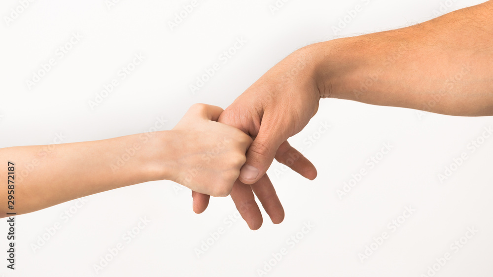 Little girl holding her daddy's finger, following father