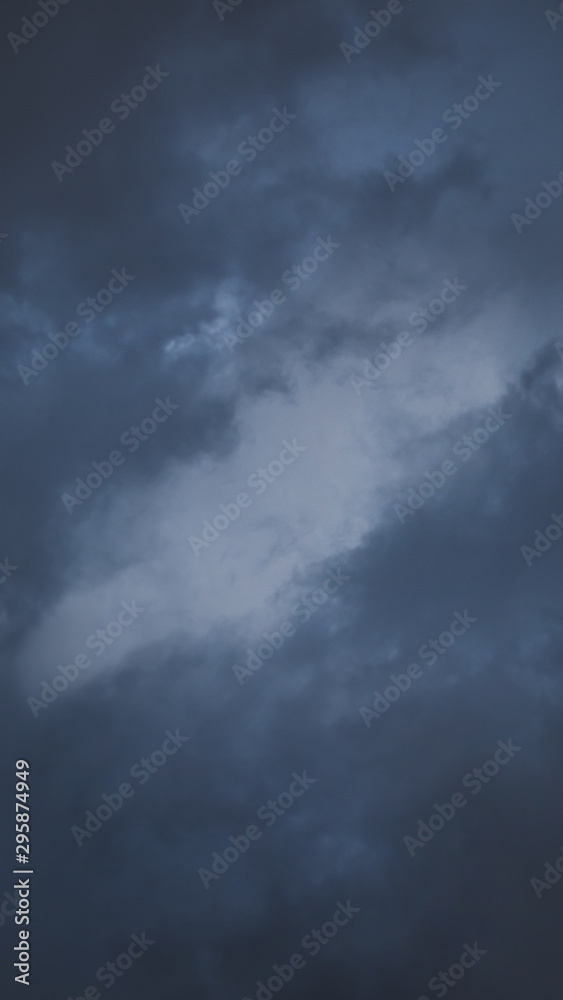 Dark rainy clouds with one lighter part in the middle Dark rainy clouds with one lighter part in the middle