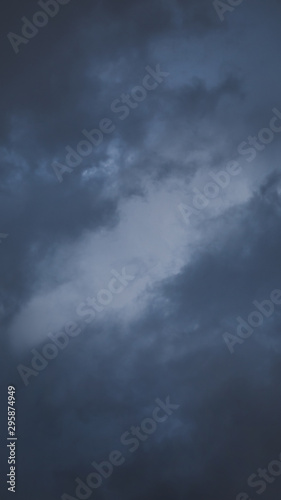 Dark rainy clouds with one lighter part in the middle