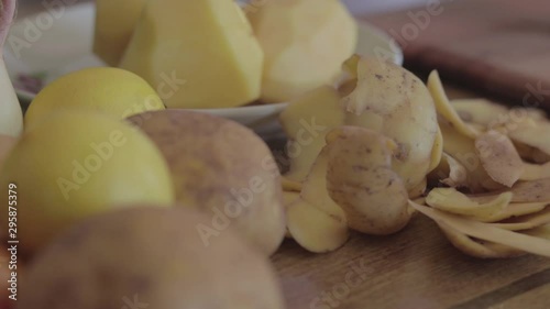 Peeled potatoes on the table. Slide shot.