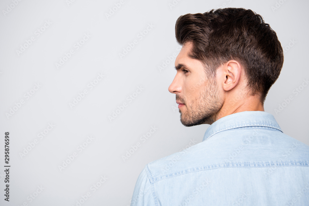 Rear view close up photo of serious concentrated attractive man looking away into empty space pensively isolated over grey color background Rear view close up photo of serious concentrated attractive man looking away into empty space pensively isolated over grey color background
