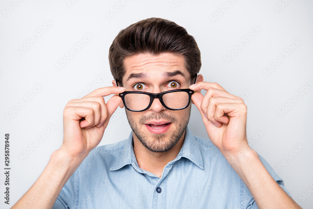 Close up photo of speechless man shocked with his eyesight corrected with new eyewear isolated over grey color background Close up photo of speechless man shocked with his eyesight corrected with new eyewear isolated over grey color background