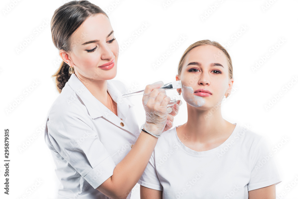 Beautician applies a mask for rejuvenation on the face of a beautiful girl. Beautician applies a mask for rejuvenation on the face of a beautiful girl.