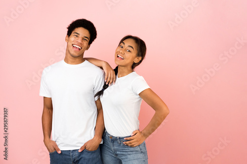 Lovely team. Teen couple posing on pink background