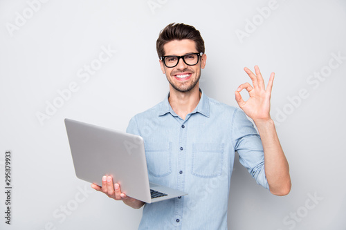 Photo of beaming brown haired cheerful positive kind friendly business trainer having done his teaching project to be shown to his students showing ok sign isolated over grey color background photo