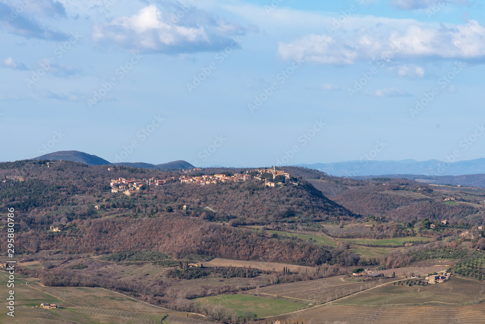 Picturesque winter landscape view of Tuscany with stone houses, colorful hills, fields and vineyards in Italy.