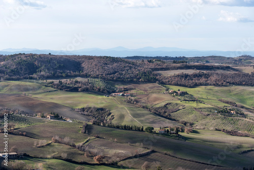 Picturesque winter landscape view of Tuscany with stone houses, colorful hills, fields and vineyards in Italy.