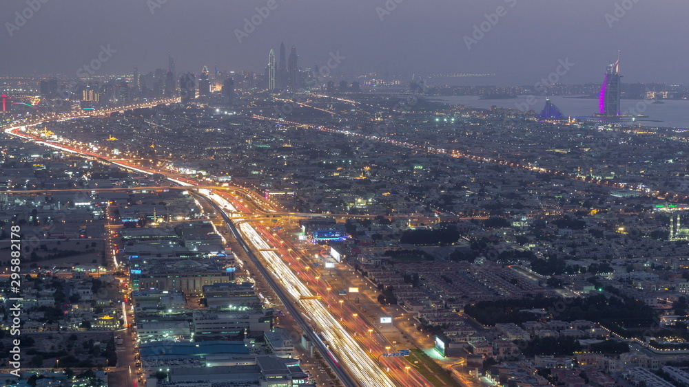 Fototapeta premium Aerial view to traffic on Sheikh Zayed road and intersection day to night timelapse, Dubai, United Arab Emirates