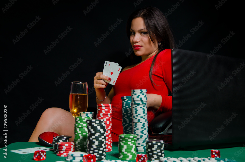 Sexy girl in red dress playing poker online concept, girl in front of  laptop and poker chips, holding cards foto de Stock | Adobe Stock