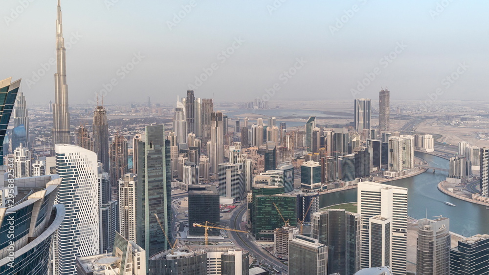 Naklejka premium Panoramic aerial view of business bay towers in Dubai at evening timelapse.