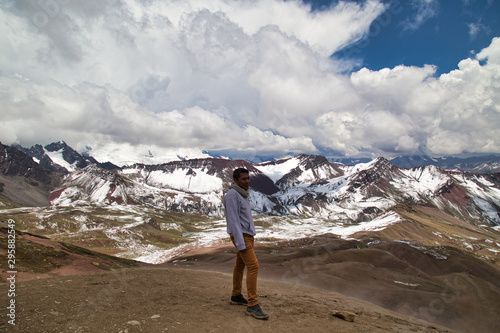 Man with panoramic view. Hiking scene in Vinicunca, Cusco region, Peru. Montana of Seven Colors, Rainbow Mountain © @Nailotl