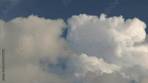 Clouds moving in the blue sky in opposite direction, realtime footage, closing in photo