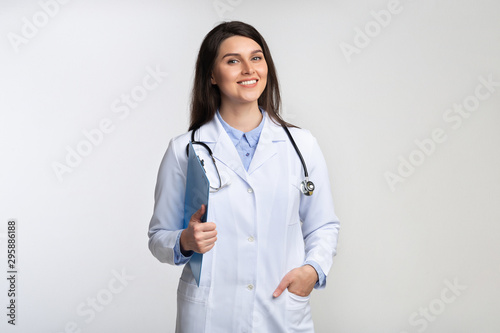 Doctor Lady Smiling At Camera Standing Over Gray Studio Background