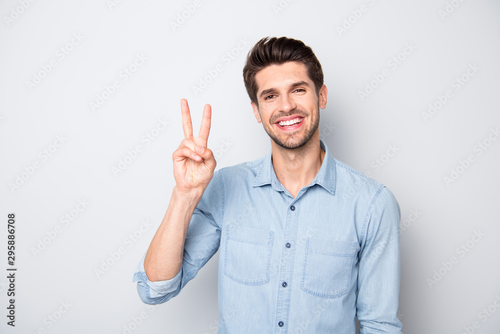 Portrait of positive cheerful guy have fun with his friends on weekend make v-signs wear casual style outfit isolated over grey color background Portrait of positive cheerful guy have fun with his friends on weekend make v-signs wear casual style outfit isolated over grey color background