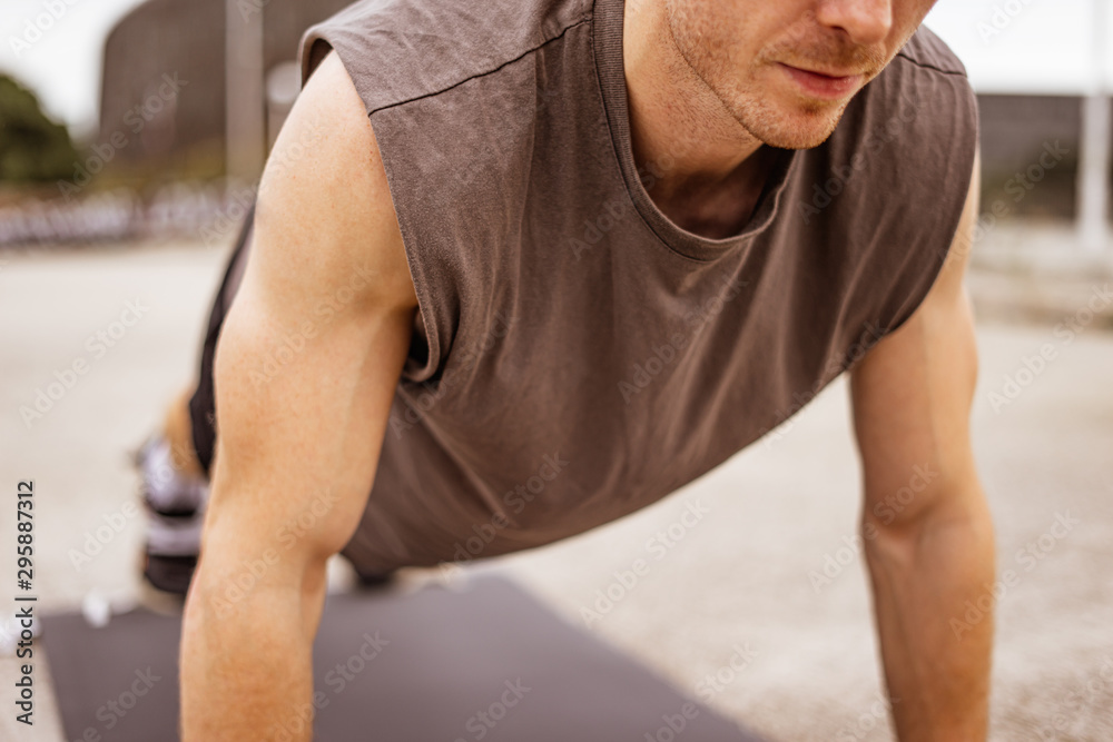 Young athletic man doing workout. Fitness outdoors. Push ups. Urban background. Young athletic man doing workout. Fitness outdoors. Push ups. Urban background.