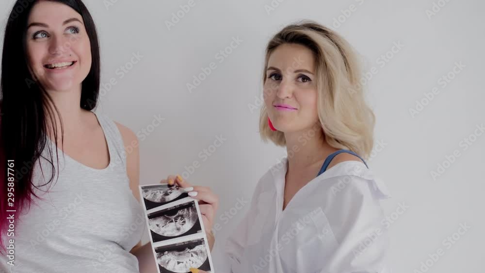 Mother and Pregnant Daughter Talking and Looking at Pictures of Ultrasound. Two Woman have Fun Chatting. Happy Family Have Joyfully Communication. Beautiful Women Look at Ultrasonic Images. Mother and Pregnant Daughter Talking and Looking at Pictures of Ultrasound. Two Woman have Fun Chatting. Happy Family Have Joyfully Communication. Beautiful Women Look at Ultrasonic Images.