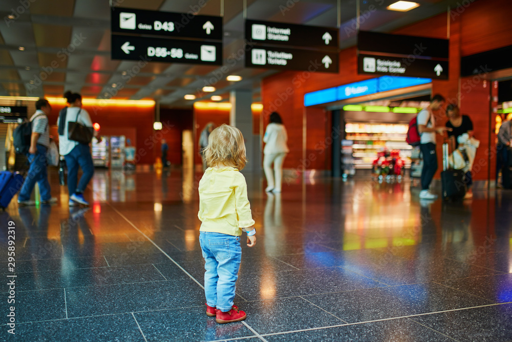 Adorable little girl alone in the airport - obrazy, fototapety, plakaty 