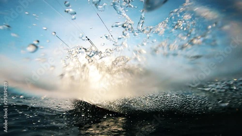 A kitesurfer splashing water while riding a board. Kite surfer kiteboarding.