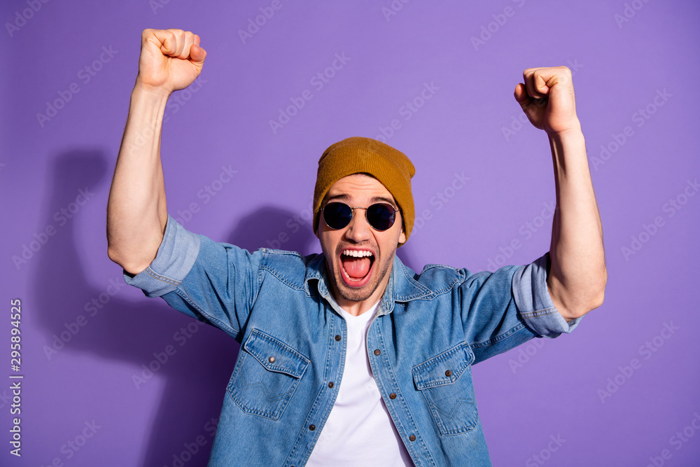 Naklejka premium Photo of trendy white cheerful handsome shouting man screaming with hands up with fists made smiling toothily celebrating victory isolated over violet color vivid background