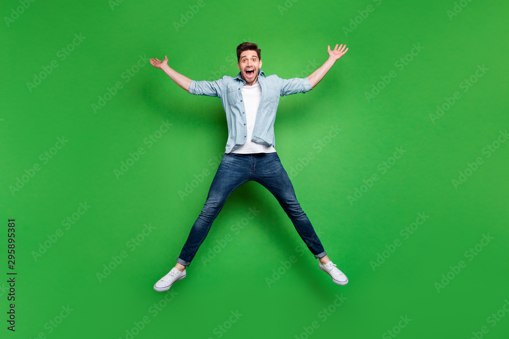 Obraz premium Full size photo of handsome guy jumping high in star shape celebrating sport competition first place winning wear casual denim outfit isolated green color background